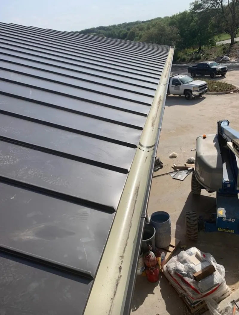 Standing seam panel and gutter detail on a metal roofing jobsite in Fort Mill